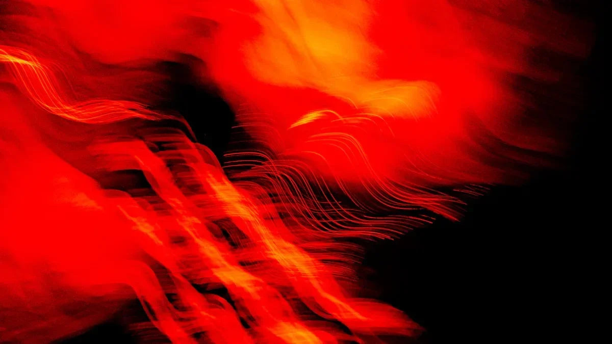 Vibrant red and orange light waves flowing against dark background, evoking LED therapy energy