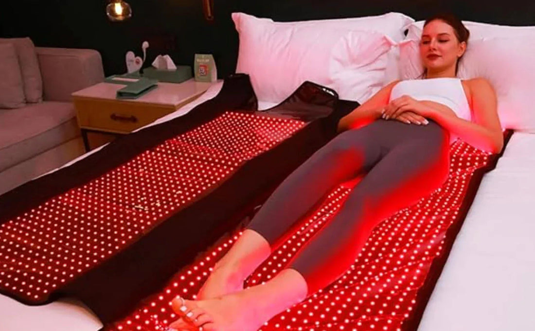 Woman relaxing on red LED light therapy mat for at-home skin and pain treatment