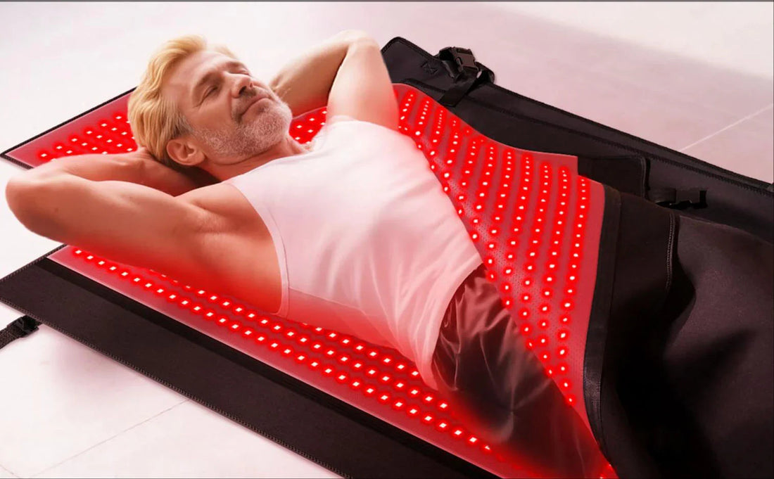 Man relaxing on red LED light therapy mat for pain relief and skin rejuvenation at home